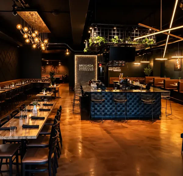 Main dining room at Brugada Kitchen & Bar with the neon Brugada sign, communal tables and the bar